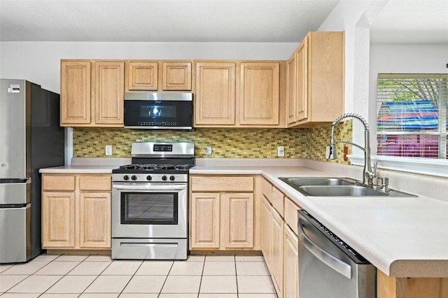 kitchen with backsplash, light tile patterned floors, stainless steel appliances, sink, and light brown cabinets