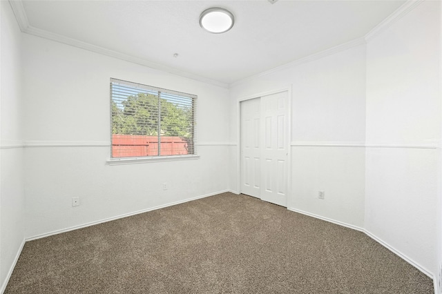 unfurnished room with crown molding and dark colored carpet