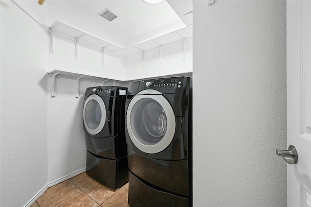 laundry area featuring light tile patterned floors and washer and clothes dryer