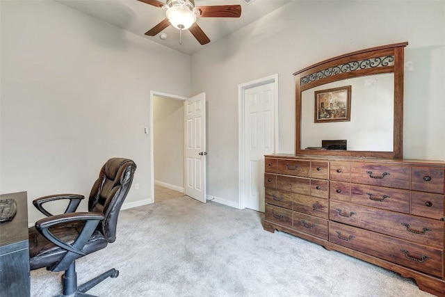 office area with light carpet, a ceiling fan, and baseboards