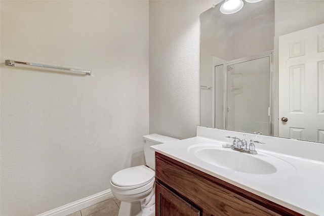 bathroom with tile patterned flooring, baseboards, toilet, a stall shower, and vanity