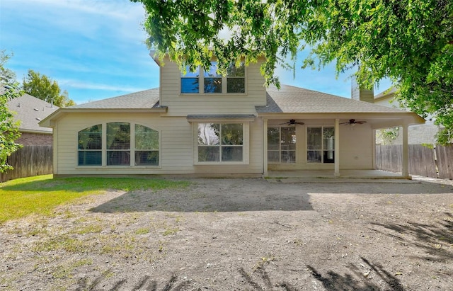 back of property with a patio, a fenced backyard, a shingled roof, a chimney, and ceiling fan