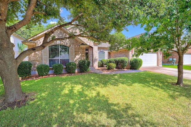 view of front of property with a garage, a front yard, concrete driveway, and brick siding