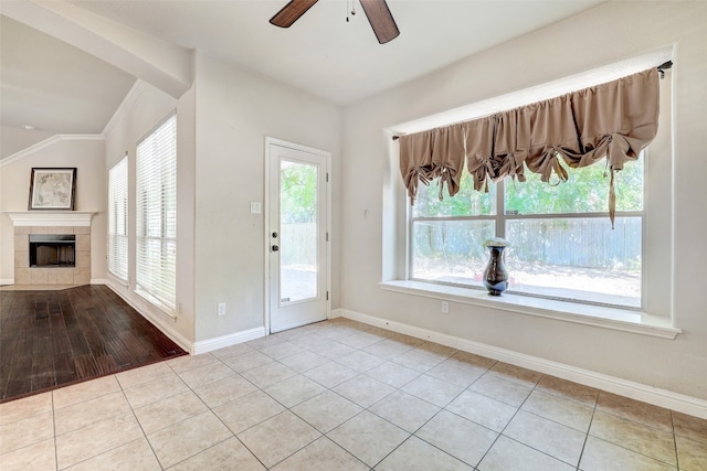 entryway featuring ceiling fan, a tile fireplace, plenty of natural light, and light hardwood / wood-style floors