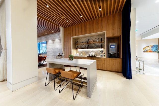 bar with light hardwood / wood-style floors and wood walls