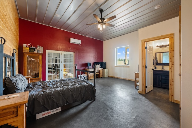 bedroom with wood ceiling, ceiling fan, a wall unit AC, and ensuite bath