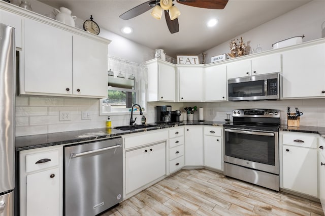 kitchen with white cabinetry, sink, stainless steel appliances, and ceiling fan