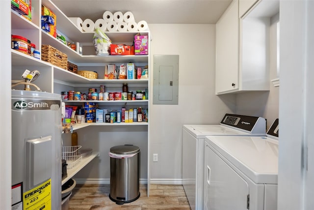 clothes washing area featuring light wood-type flooring, cabinets, water heater, electric panel, and washing machine and dryer