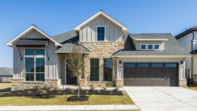 view of front of property featuring roof with shingles, concrete driveway, board and batten siding, a garage, and stone siding