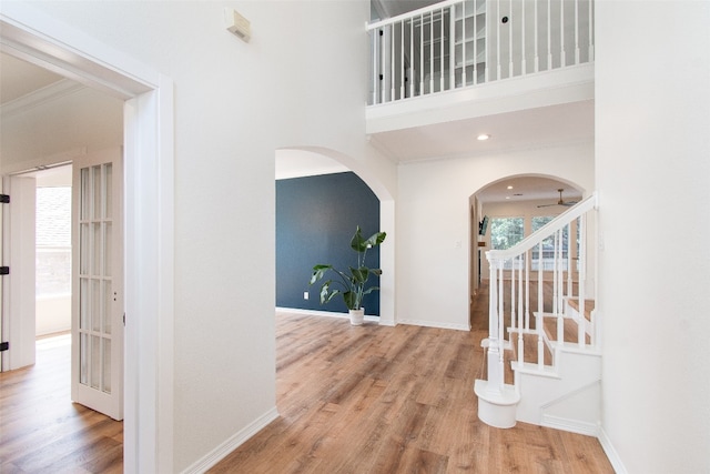 interior space featuring crown molding, hardwood / wood-style flooring, and a towering ceiling