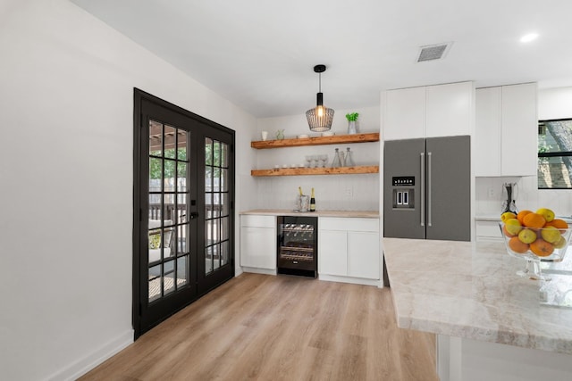 kitchen with beverage cooler, a healthy amount of sunlight, light hardwood / wood-style flooring, and high quality fridge