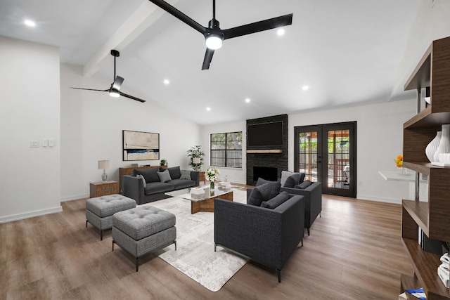 living room featuring ceiling fan, hardwood / wood-style floors, lofted ceiling with beams, and a fireplace