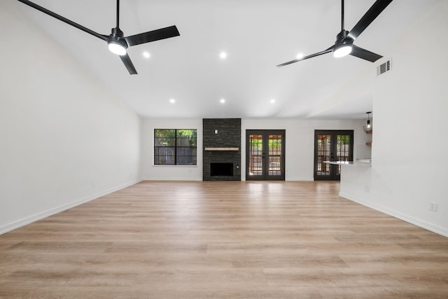 unfurnished living room with a fireplace, light wood-type flooring, high vaulted ceiling, and ceiling fan