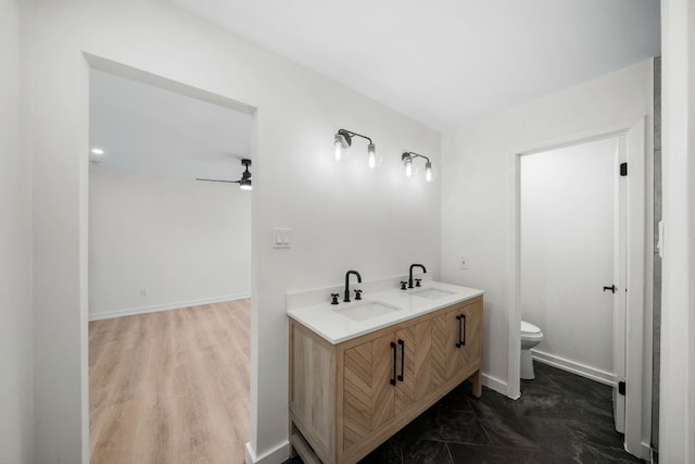 bathroom with vanity, toilet, ceiling fan, and hardwood / wood-style flooring