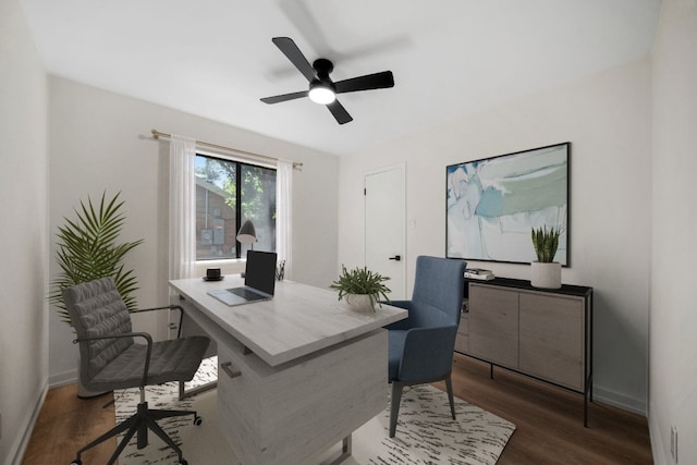 home office with dark wood-type flooring and ceiling fan