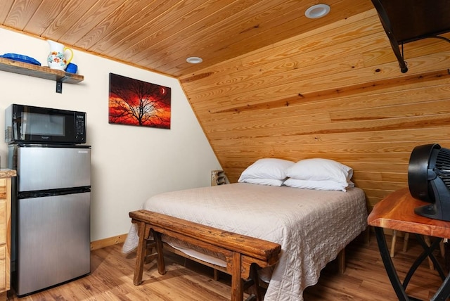 bedroom with light hardwood / wood-style flooring, stainless steel refrigerator, and wood ceiling