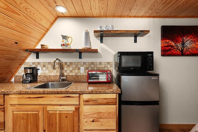 kitchen featuring sink, backsplash, stainless steel fridge, vaulted ceiling, and wood ceiling