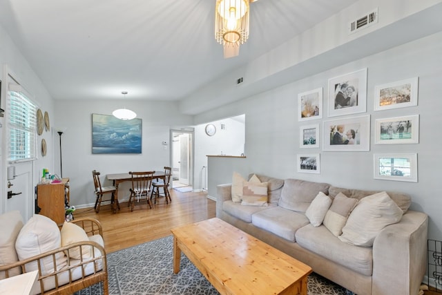 living room featuring plenty of natural light, wood finished floors, visible vents, and baseboards