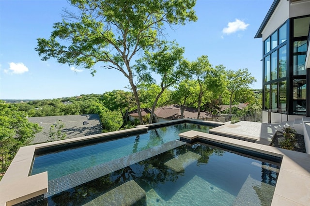 view of swimming pool featuring an in ground hot tub