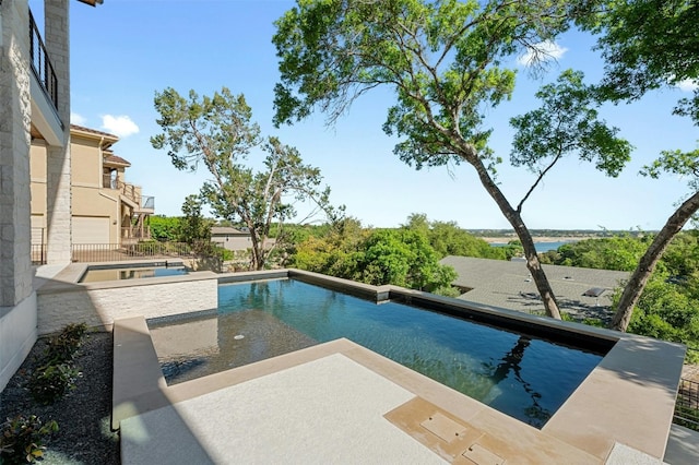 view of swimming pool with an in ground hot tub