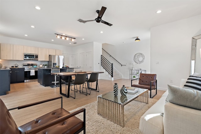 living room featuring ceiling fan and light hardwood / wood-style floors