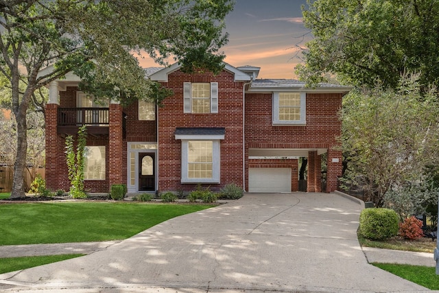 view of front of house featuring a balcony, a garage, and a lawn