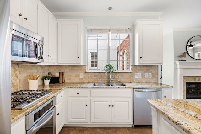 kitchen with white cabinets, decorative light fixtures, sink, and appliances with stainless steel finishes