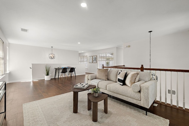 living room with hardwood / wood-style floors and an inviting chandelier