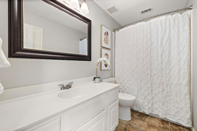 bathroom featuring curtained shower, vanity, and toilet