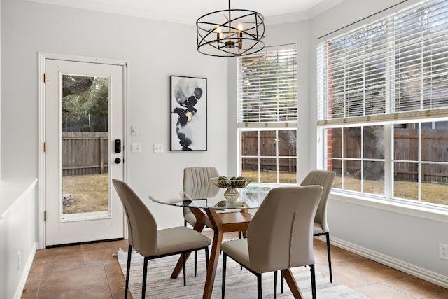 dining room featuring a wealth of natural light, crown molding, and a notable chandelier