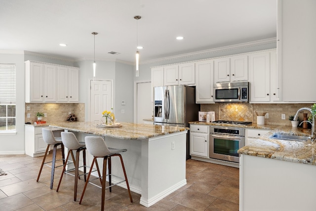 kitchen with pendant lighting, a kitchen island, sink, and appliances with stainless steel finishes