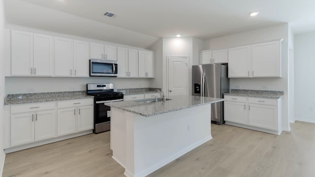 kitchen with white cabinets, appliances with stainless steel finishes, light wood-type flooring, and sink