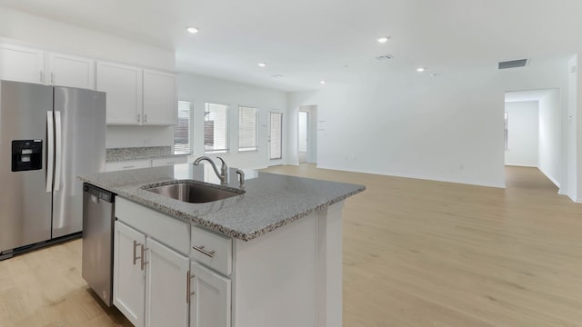 kitchen featuring appliances with stainless steel finishes, light hardwood / wood-style floors, white cabinetry, and sink