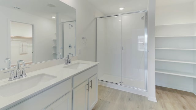 bathroom featuring wood-type flooring, vanity, and a shower with shower door