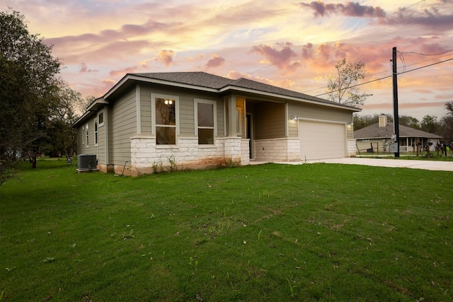 prairie-style house with a yard, a garage, and central air condition unit