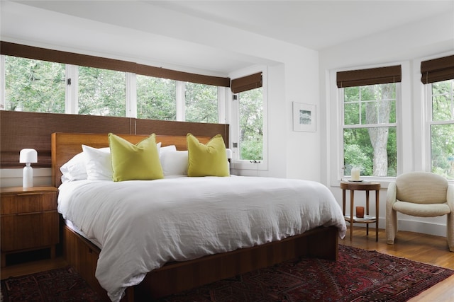 bedroom with hardwood / wood-style floors and multiple windows