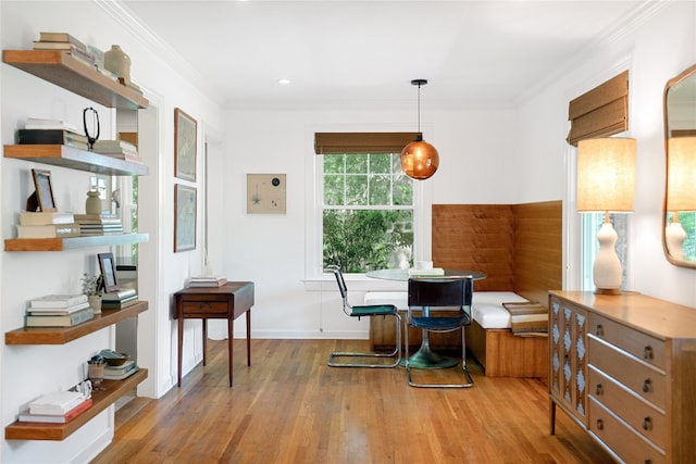 dining room with light hardwood / wood-style floors and crown molding