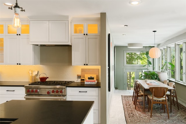 kitchen featuring pendant lighting, white cabinets, decorative backsplash, and stainless steel range