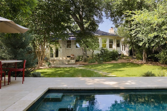 view of pool with a lawn and a patio area