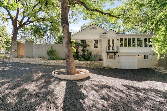 back of house with a garage and central air condition unit