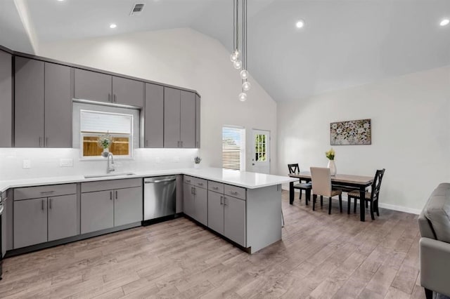 kitchen with gray cabinetry, dishwasher, light wood-type flooring, sink, and kitchen peninsula