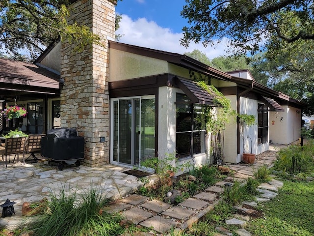 108 Overlook Cir, Wimberley, TX 78676 - rear view of property featuring stucco siding, a patio area, and a sunroom