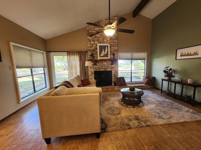 living room with hardwood / wood-style floors, ceiling fan, a fireplace, and beam ceiling