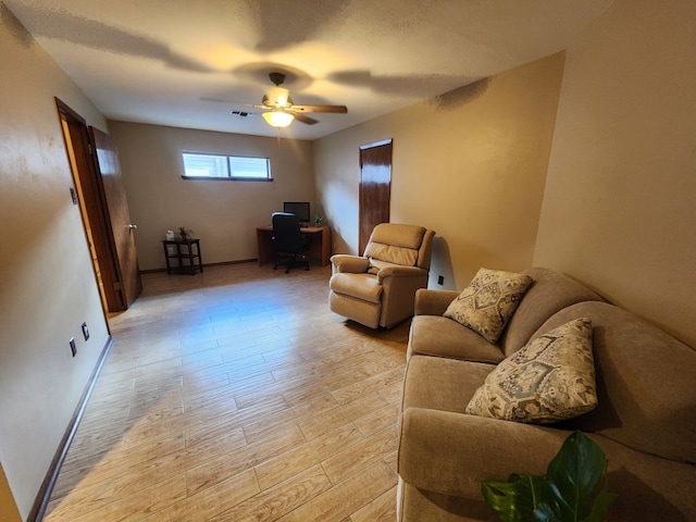 living room featuring light hardwood / wood-style flooring and ceiling fan