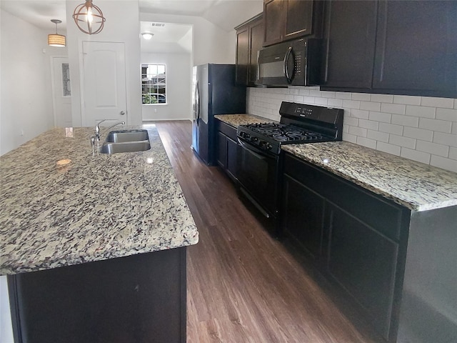 kitchen with dark hardwood / wood-style flooring, a center island with sink, black appliances, backsplash, and sink