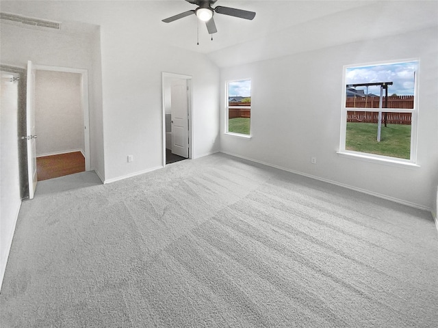 unfurnished bedroom with multiple windows, light colored carpet, and ceiling fan