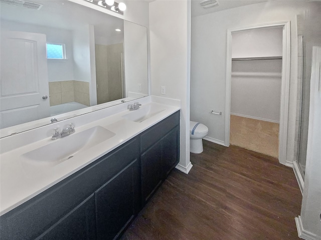 bathroom with vanity, toilet, wood-type flooring, and walk in shower