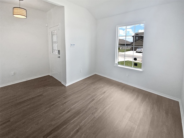 empty room featuring dark hardwood / wood-style flooring and vaulted ceiling