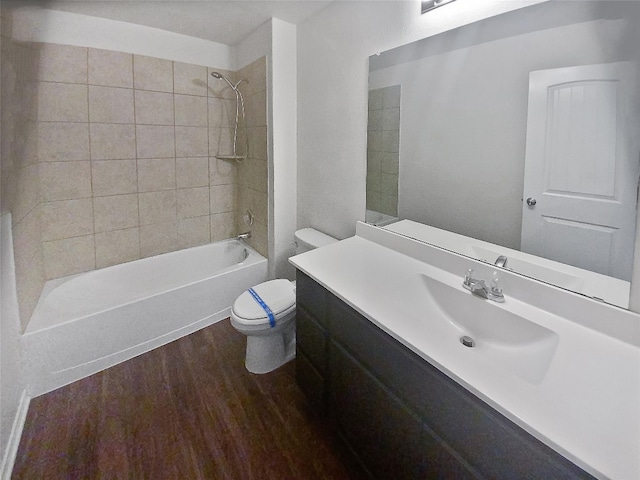 full bathroom featuring tiled shower / bath, vanity, toilet, and hardwood / wood-style flooring