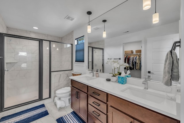 bathroom with vanity, a shower with shower door, tile walls, and toilet